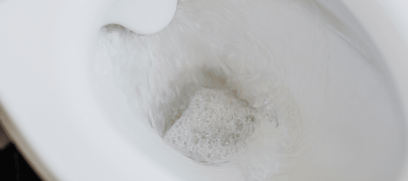 Close-up of a toilet flushing with water swirling inside the bowl.