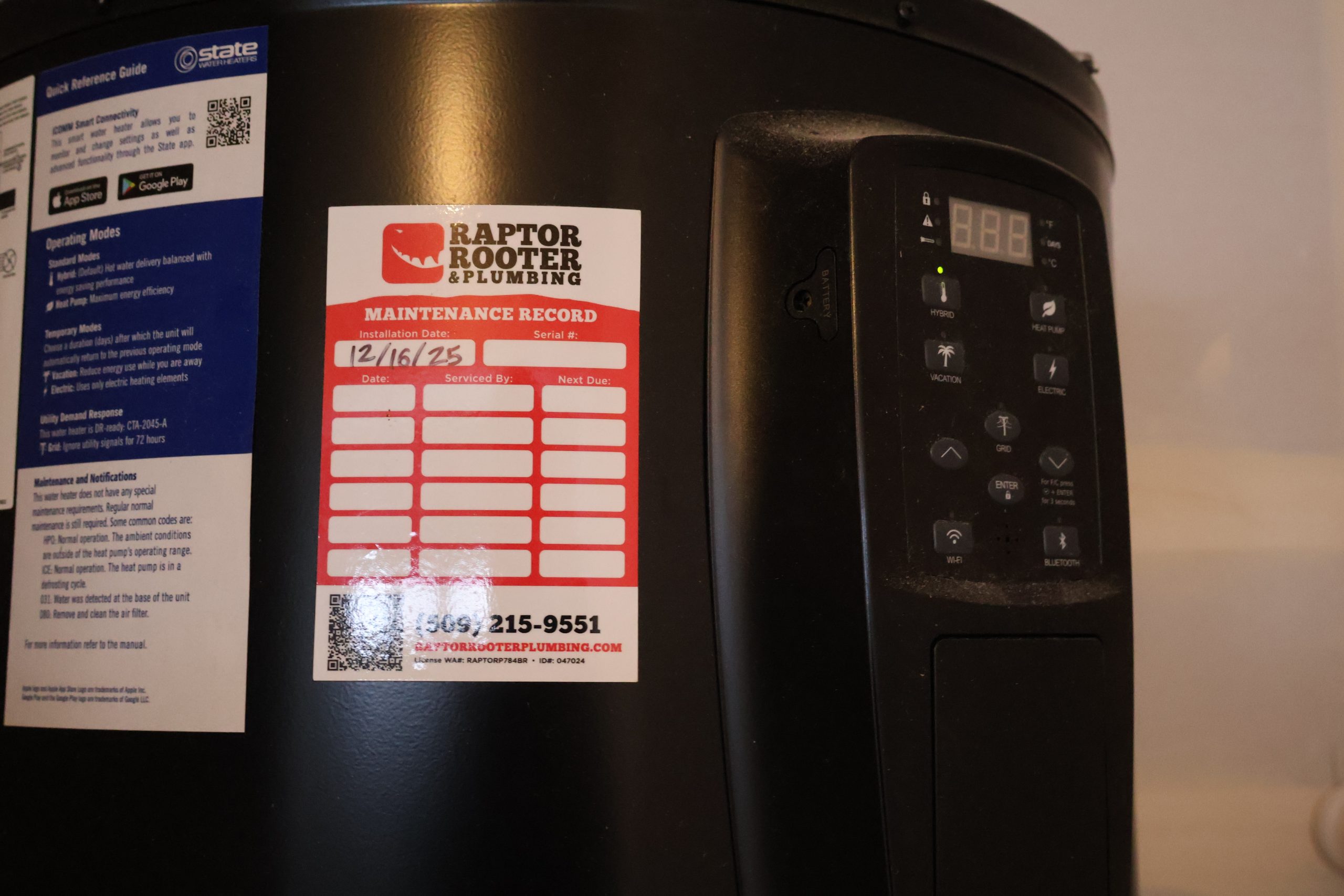 Water heater serviced by Raptor Rooter & Plumbing with a maintenance record tag in a Spokane Valley home